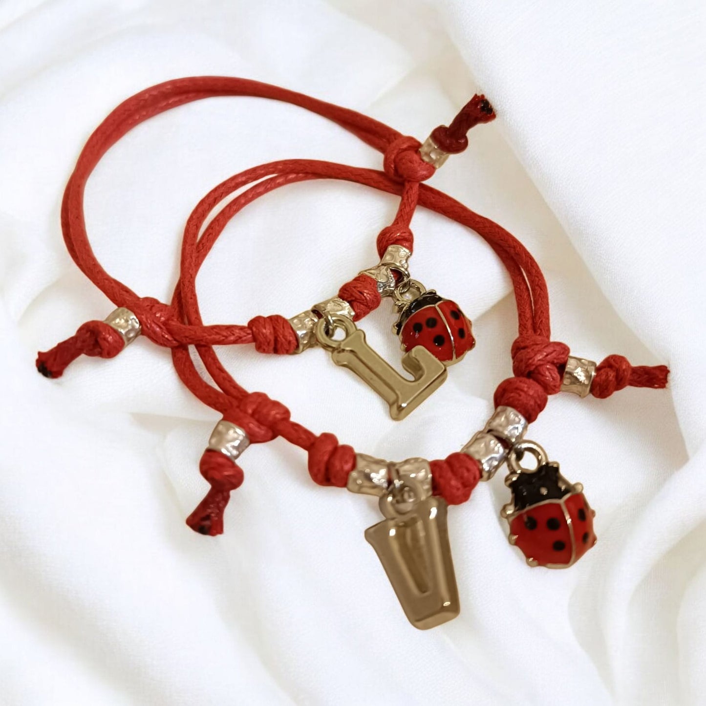 Bracciale cordino baby,4 granelli, coccinella e iniziale