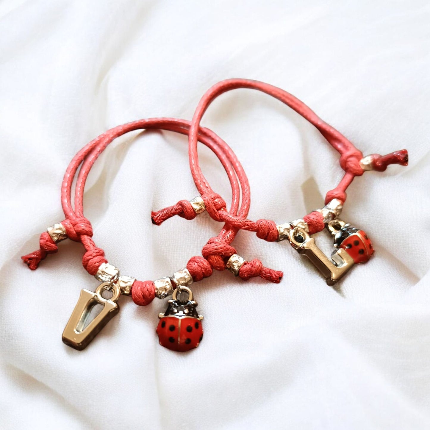 Bracciale cordino baby,4 granelli, coccinella e iniziale