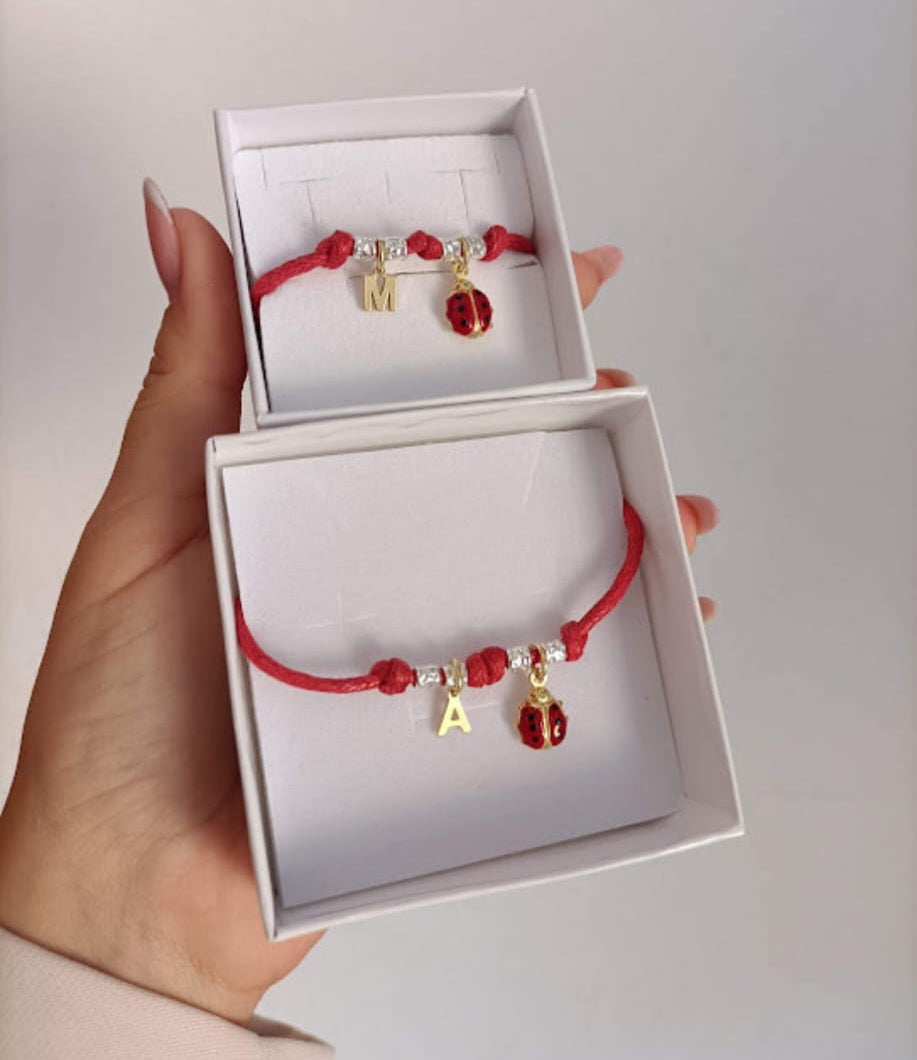 Bracciale cordino baby,4 granelli, coccinella e iniziale